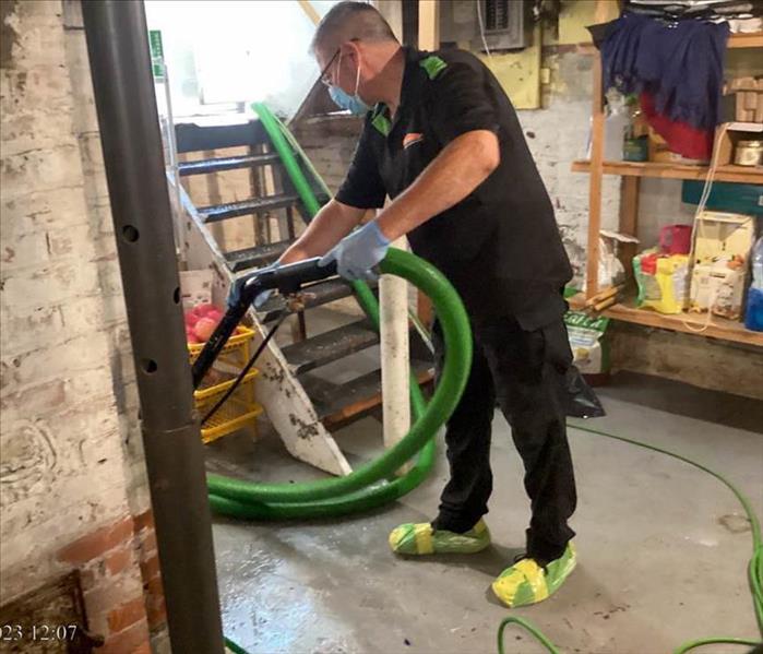 SERVPRO employee removing standing water